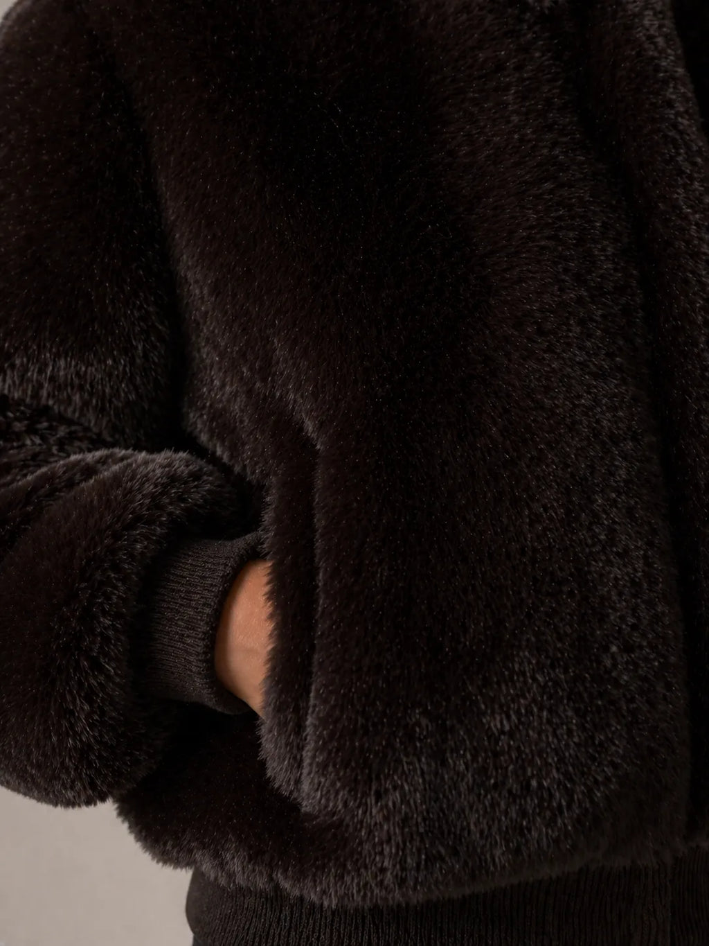 Close-up of a dark brown fleece jacket with a neutral background