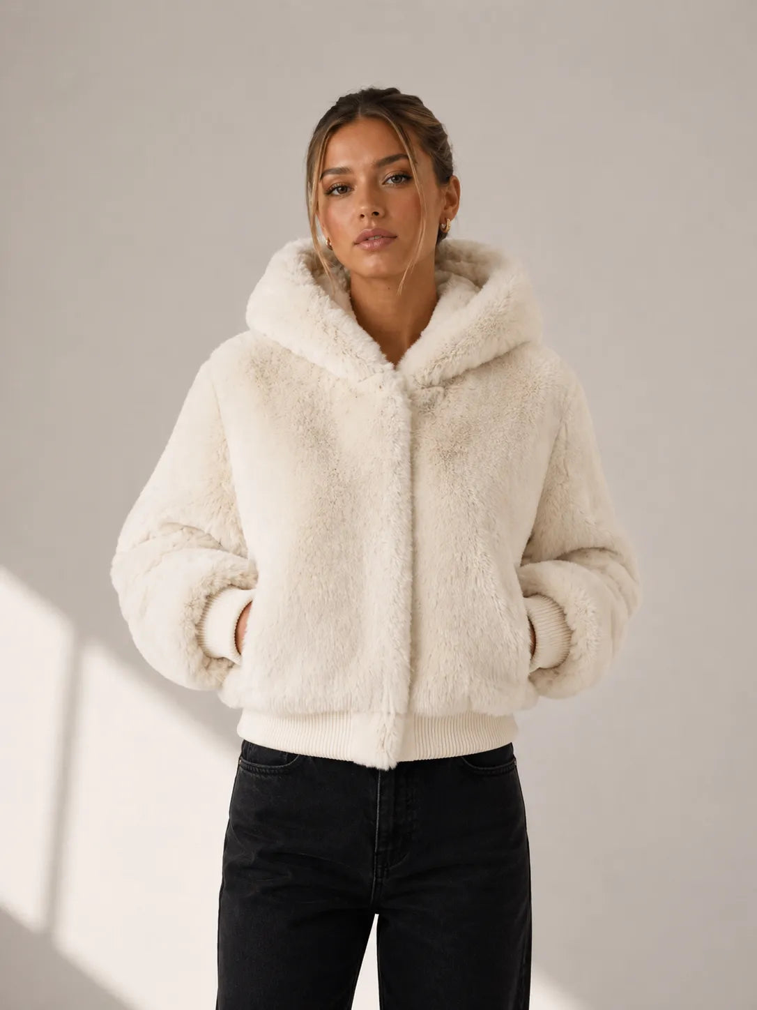 Woman wearing a cream sherpa jacket against a neutral background