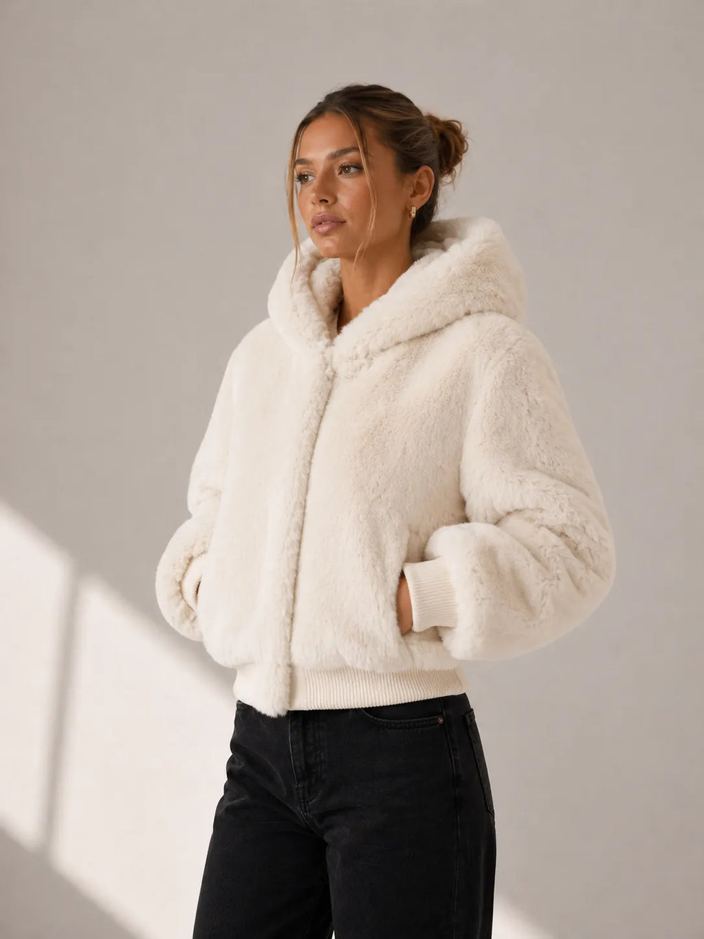 Woman wearing a cream sherpa jacket against a neutral background