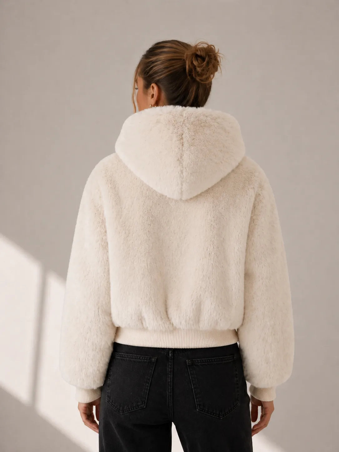 Person wearing a cream-colored fleece jacket against a neutral background
