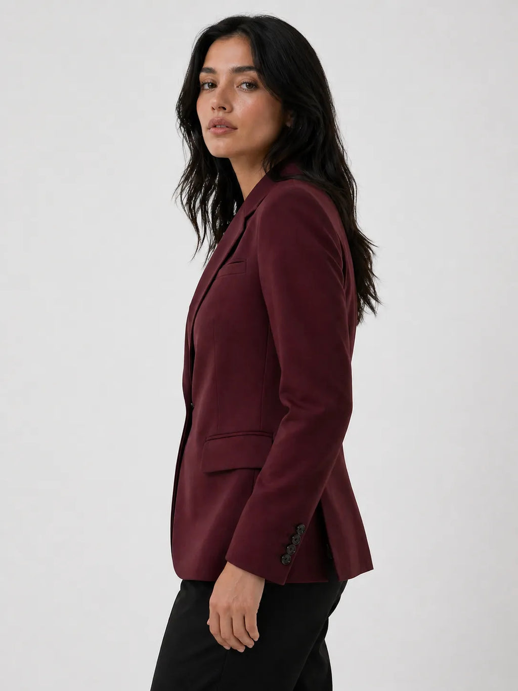 Woman wearing a burgundy blazer against a white background