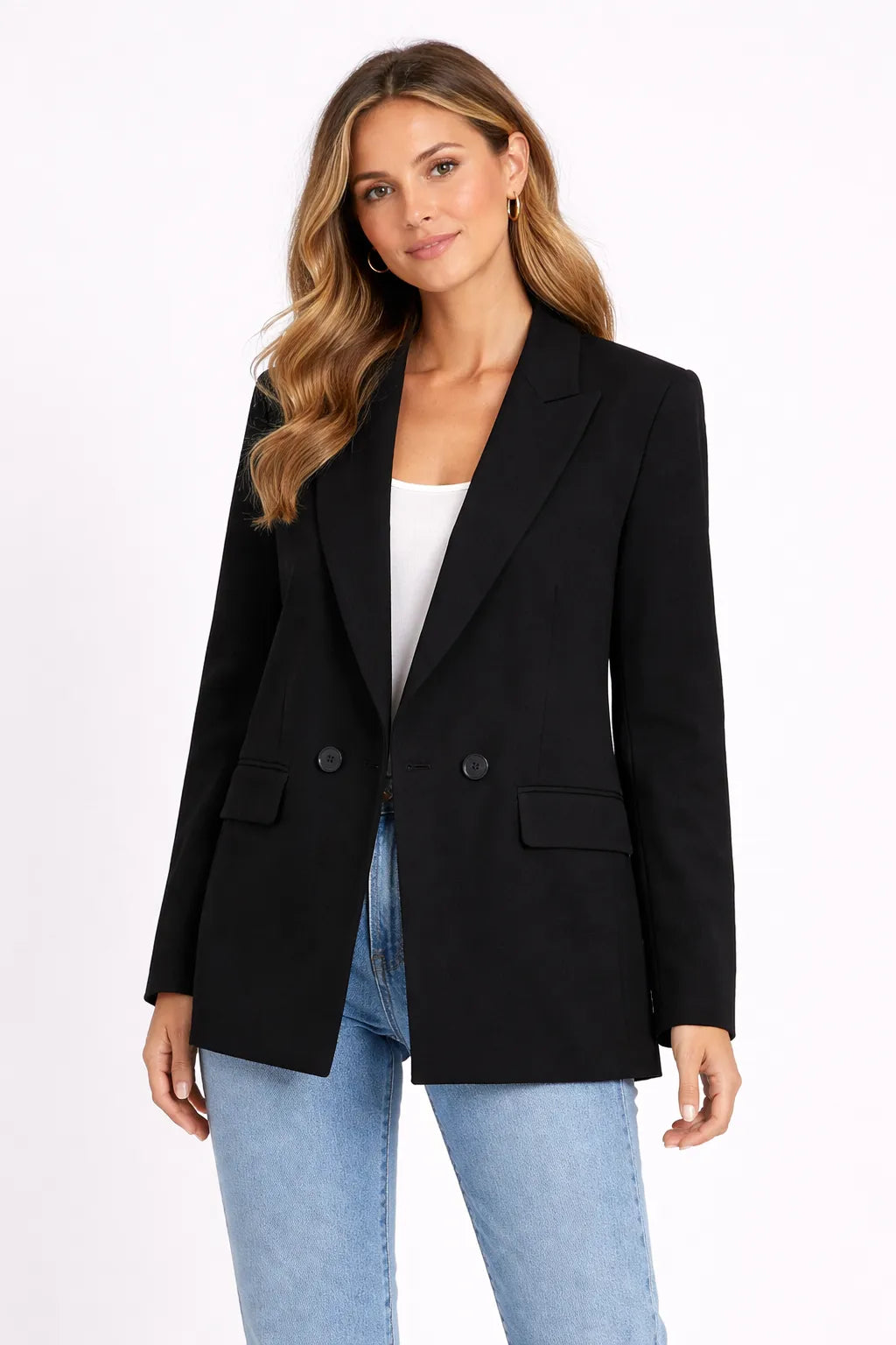 Woman wearing a black blazer and light blue jeans on a white background