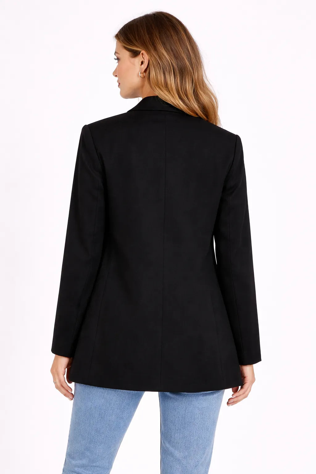 Person wearing a black blazer and light blue jeans on a white background