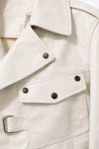Close-up of a beige trench coat with button details
