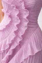 Close-up of a pink pleated fabric with ruffled layers on a light background