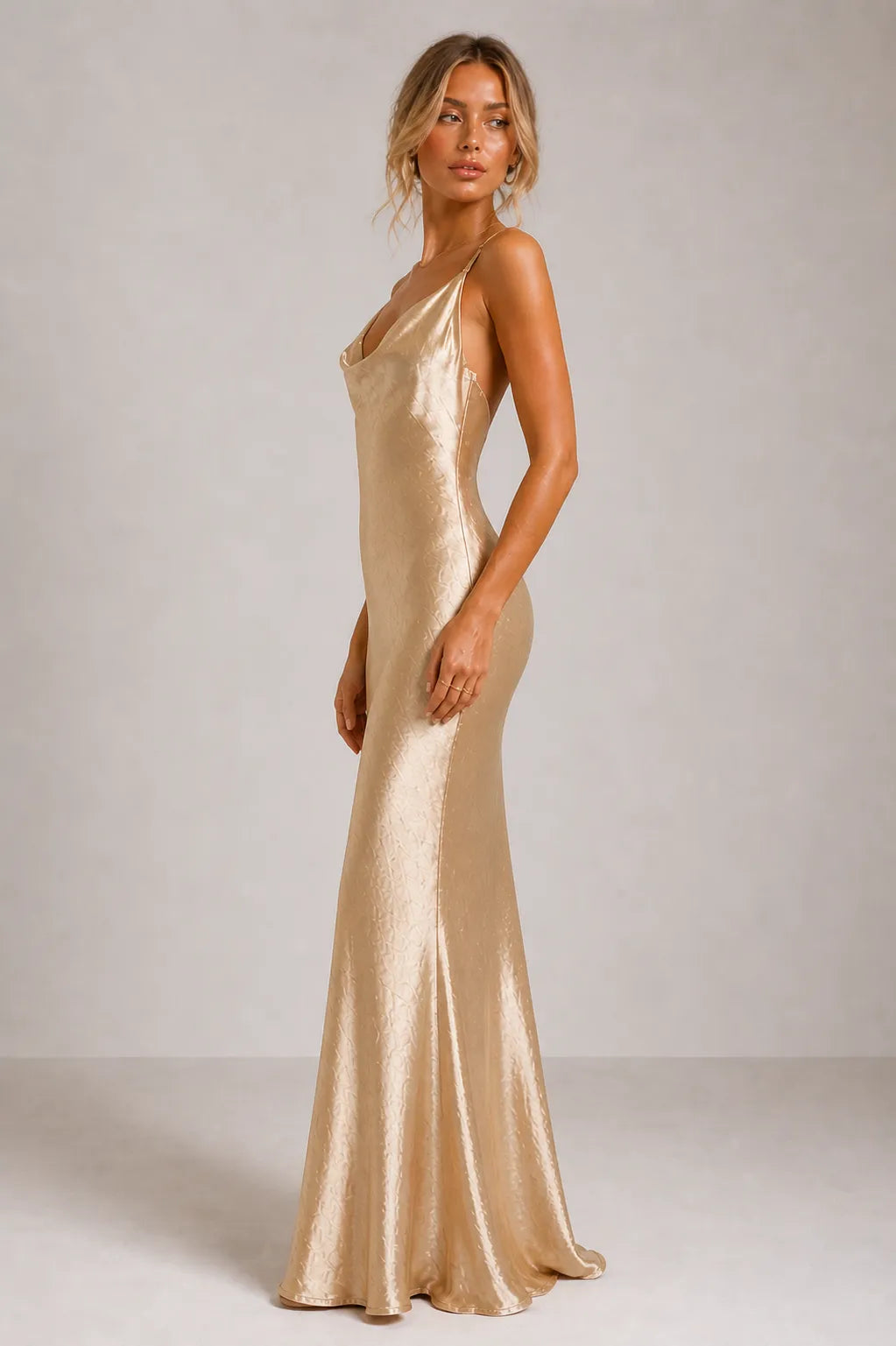 Woman wearing a gold evening gown against a plain background