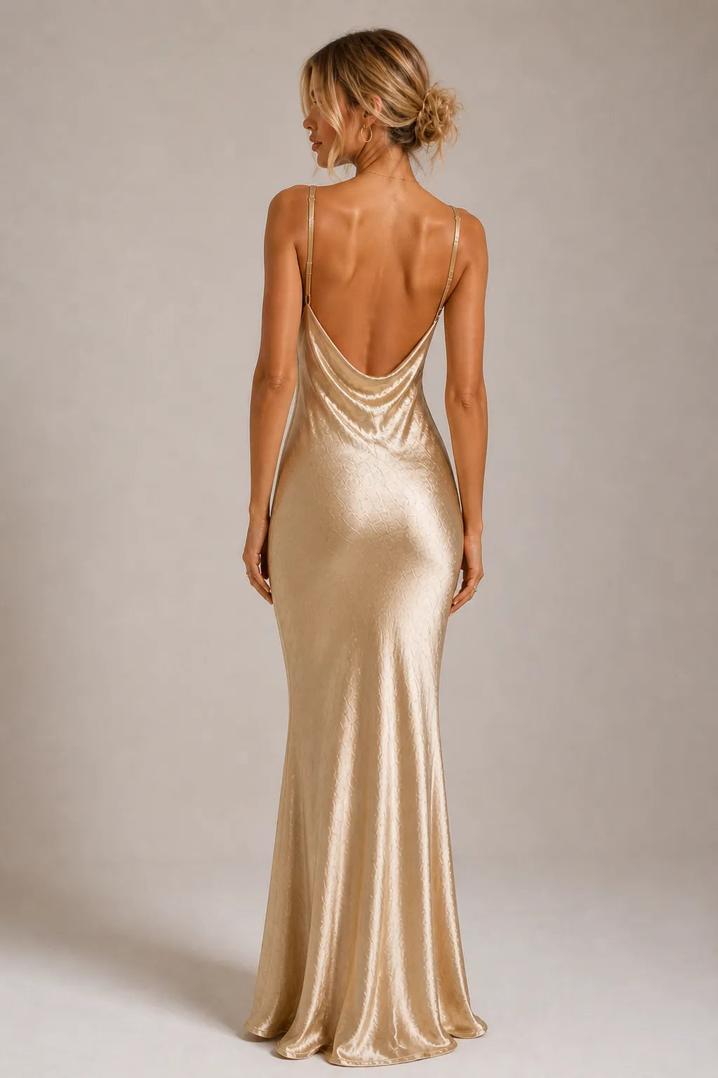 Woman wearing a gold evening gown with a plain background