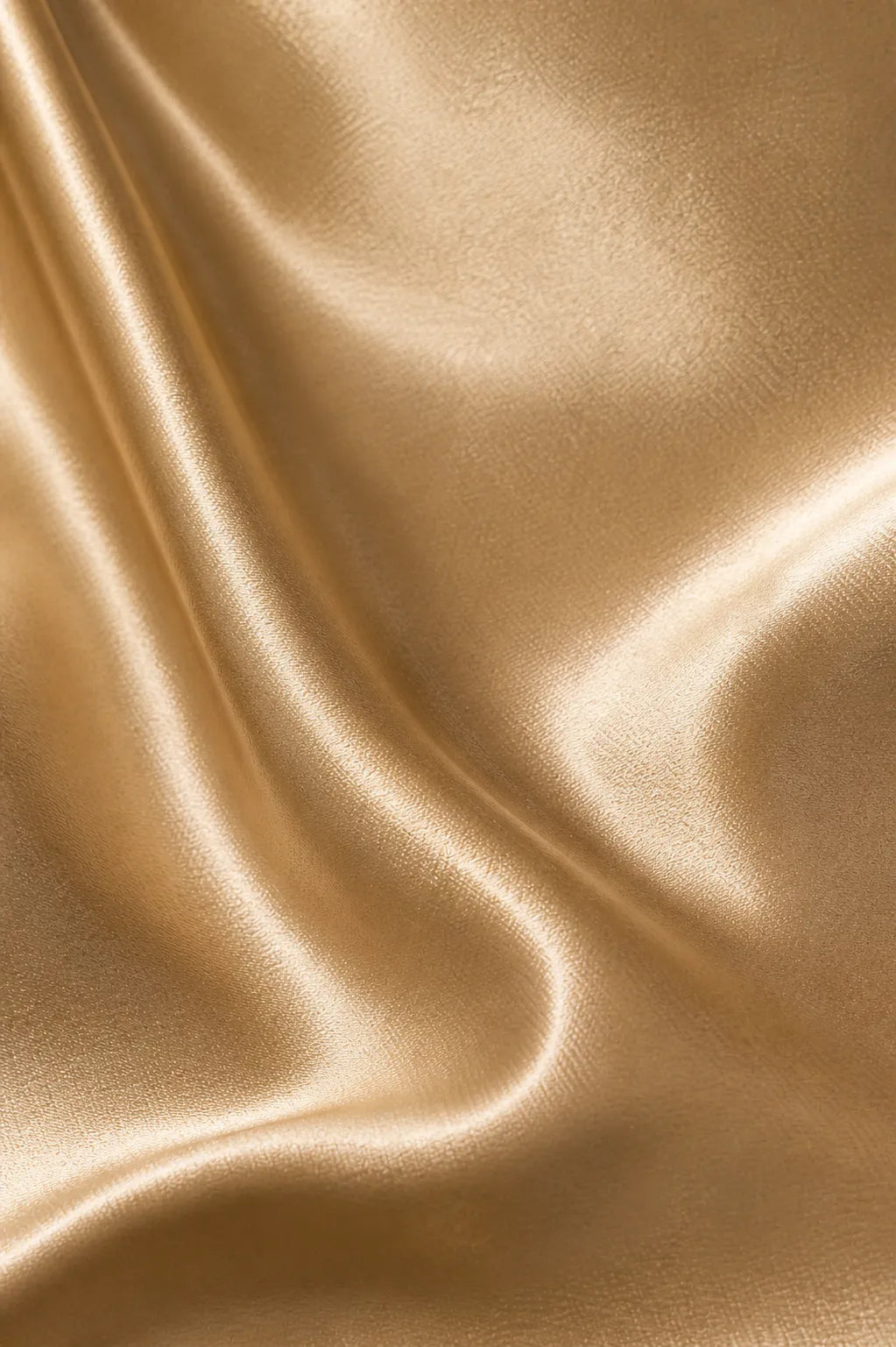 Close-up of gold satin fabric with folds