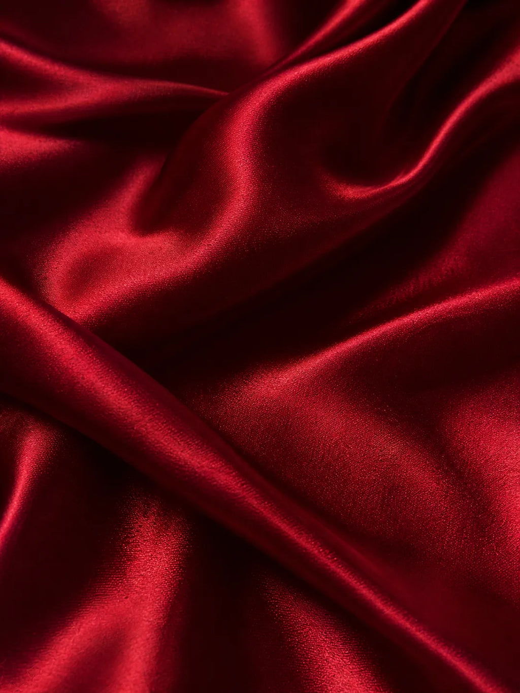 Close-up of red satin fabric with folds