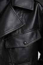 Close-up of a black leather jacket with a button