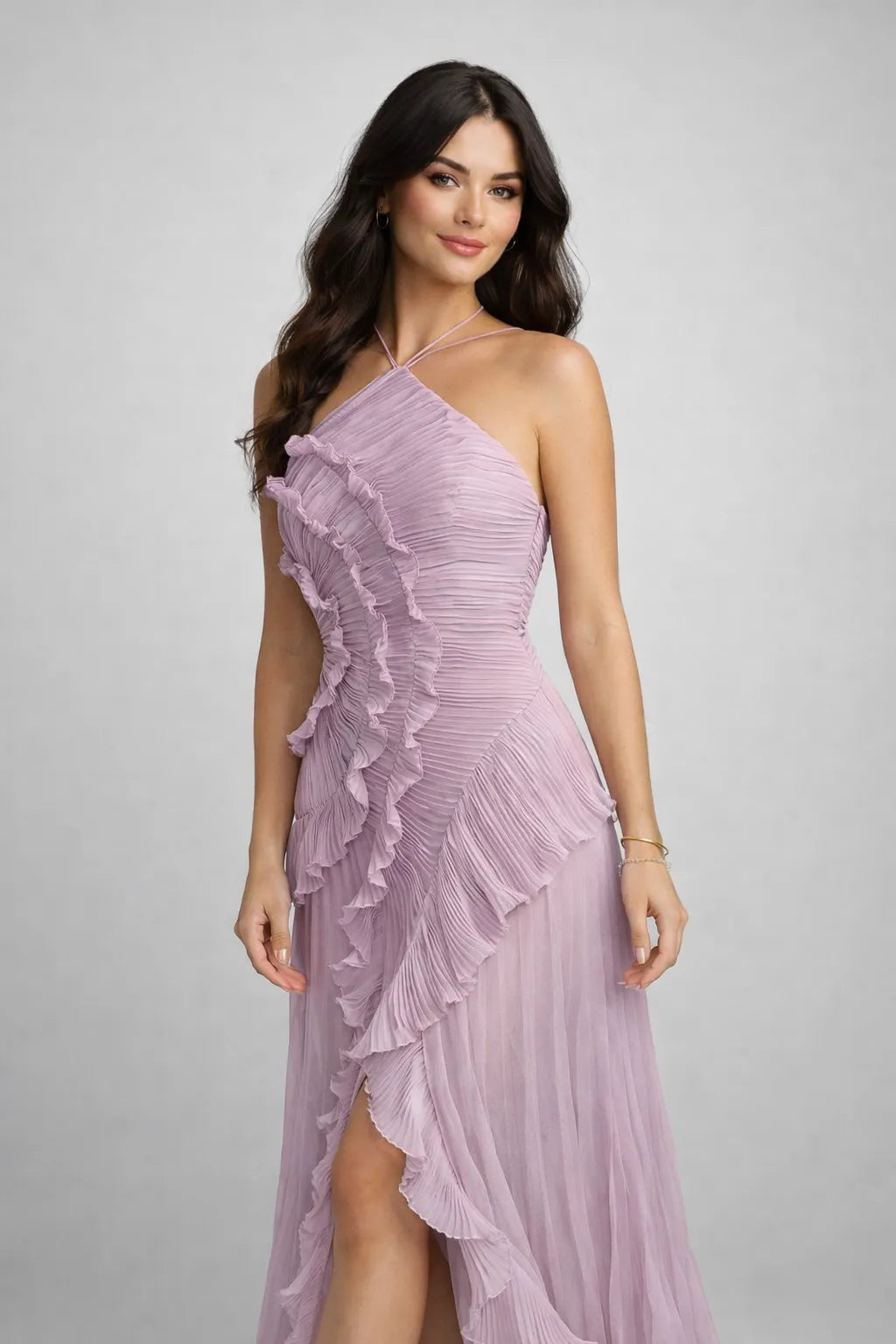 Woman wearing a pink one-shoulder dress with ruffled details on a gray background