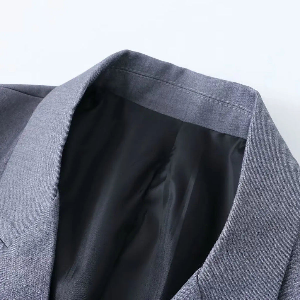 Close-up of a gray blazer on a light gray background