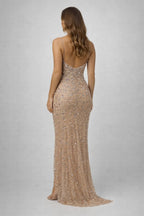 Woman wearing a sparkly gold evening gown on a plain background